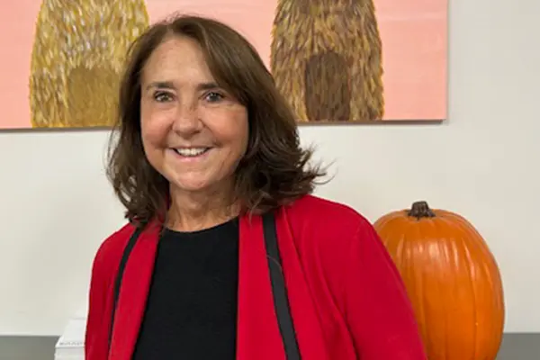 Family photo of Karren Tyler standing in front of a large pumpkin and artwork.