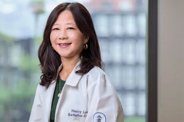 Radiation oncologist Dr. Nancy Lee, at MSK in New York City, in a white doctors’ coat. 