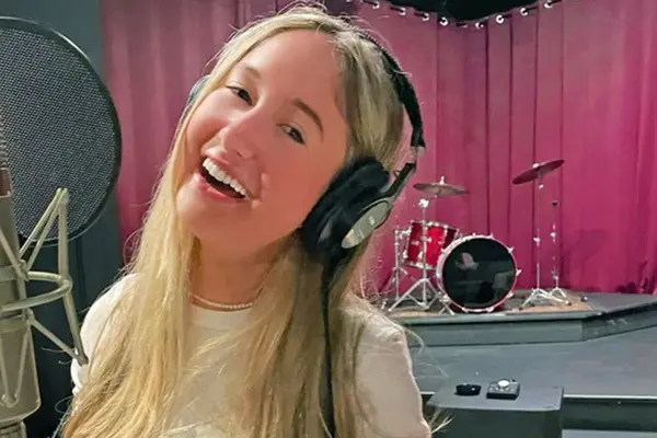 Thyroid cancer survivor Annabel Gutherz, treated for cancer at MSK, is singing in front of a microphone in a recording studio.   