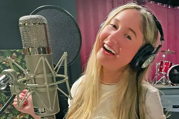 Thyroid cancer survivor Annabel Gutherz, treated for cancer at MSK, is singing in front of a microphone in a recording studio.   