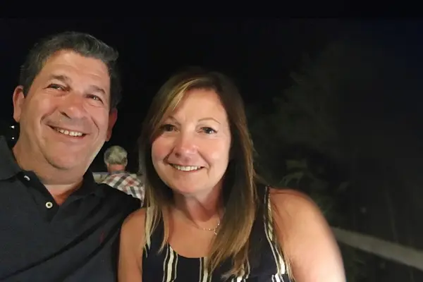 Robert Rosenfeld with his wife, both smiling, was treated at MSK with radiation therapy.    