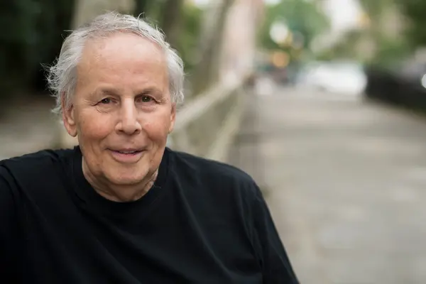 Prostate cancer survivor Michael Rosenblum, smiling, sits near a window. 