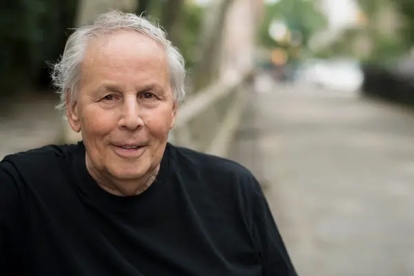Prostate cancer survivor Michael Rosenblum, smiling, sits near a window. 