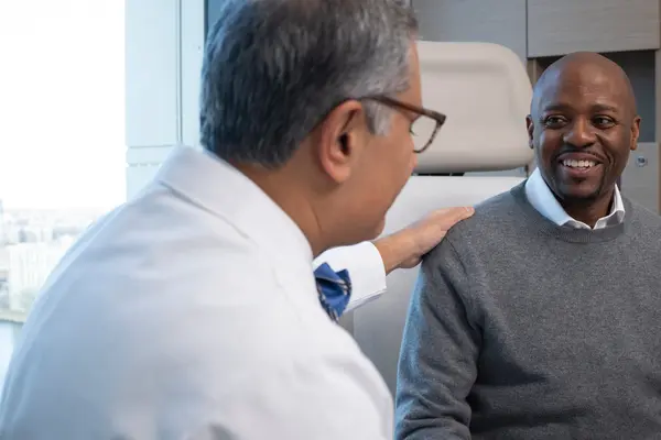 MSK urologic surgeon Dr. Behfar Ehdaie and Eddie are talking in an exam room.  