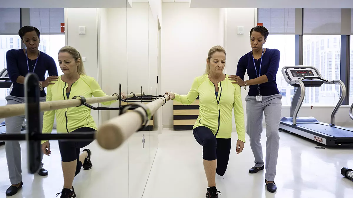 An MSK rehabilitation specialist helps a patient with physical therapy in the gym.