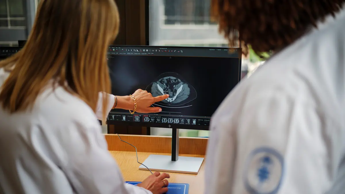 Gastrointestinal oncologist Dr. Andrea Cercek and nurse practitioner Natasha Pinheiro review patient scans on a computer.   