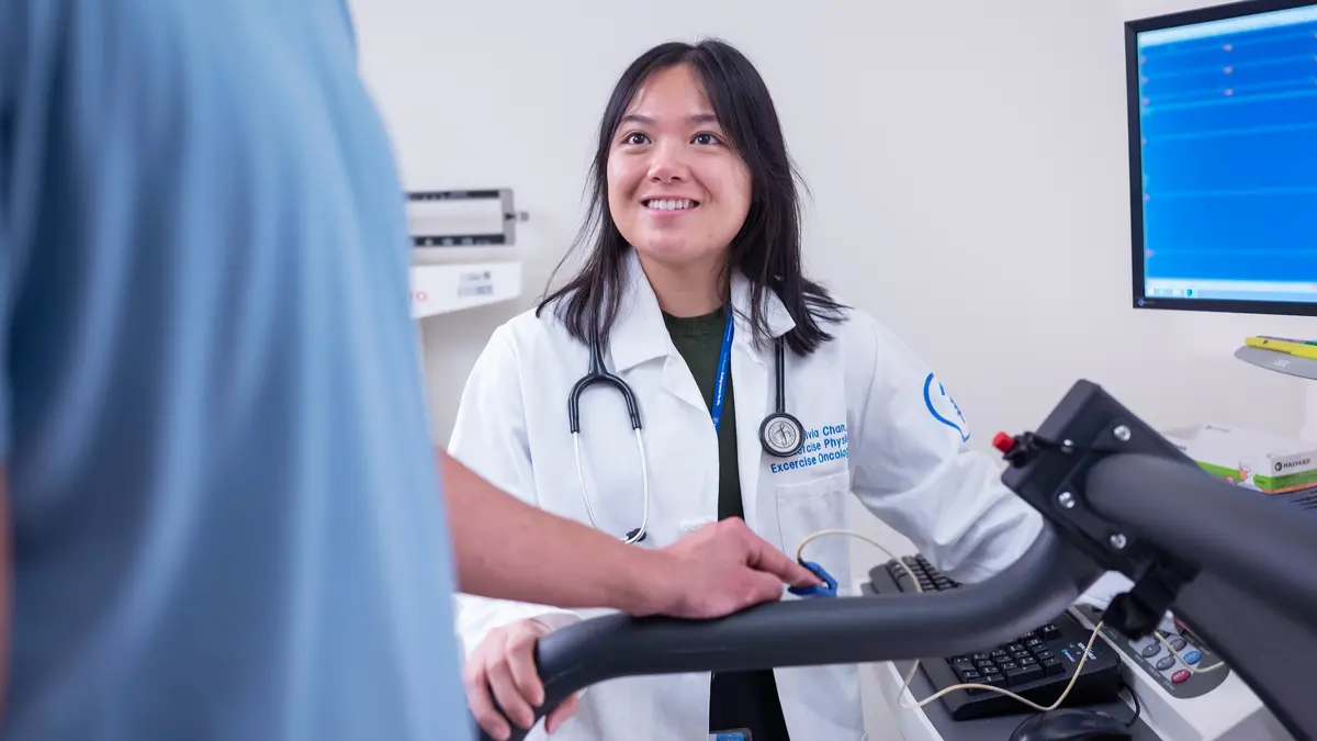 An exercise physiologist works with an MSK patient using exercise equipment.  