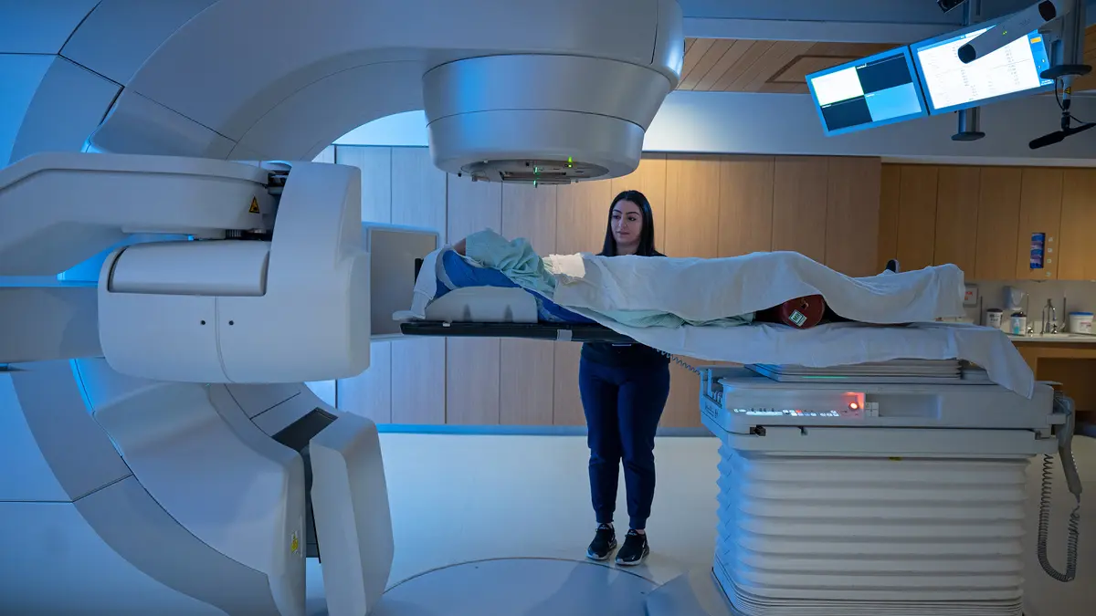 An MSK radiation therapist treats her patient with radiation therapy using a very large machine called a linear accelerator. 