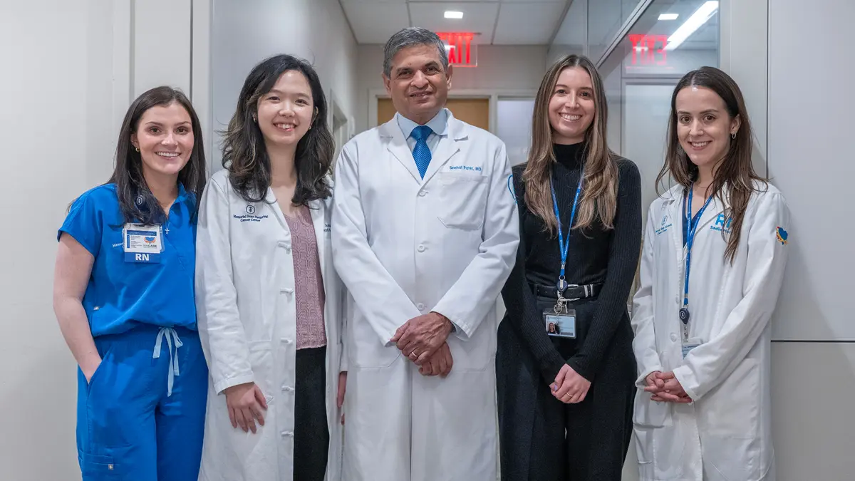 Dr. Patel is standing with 4 women on his clinical care team: 2 registered nurses, a physician assistant, and an office coordinator. 
