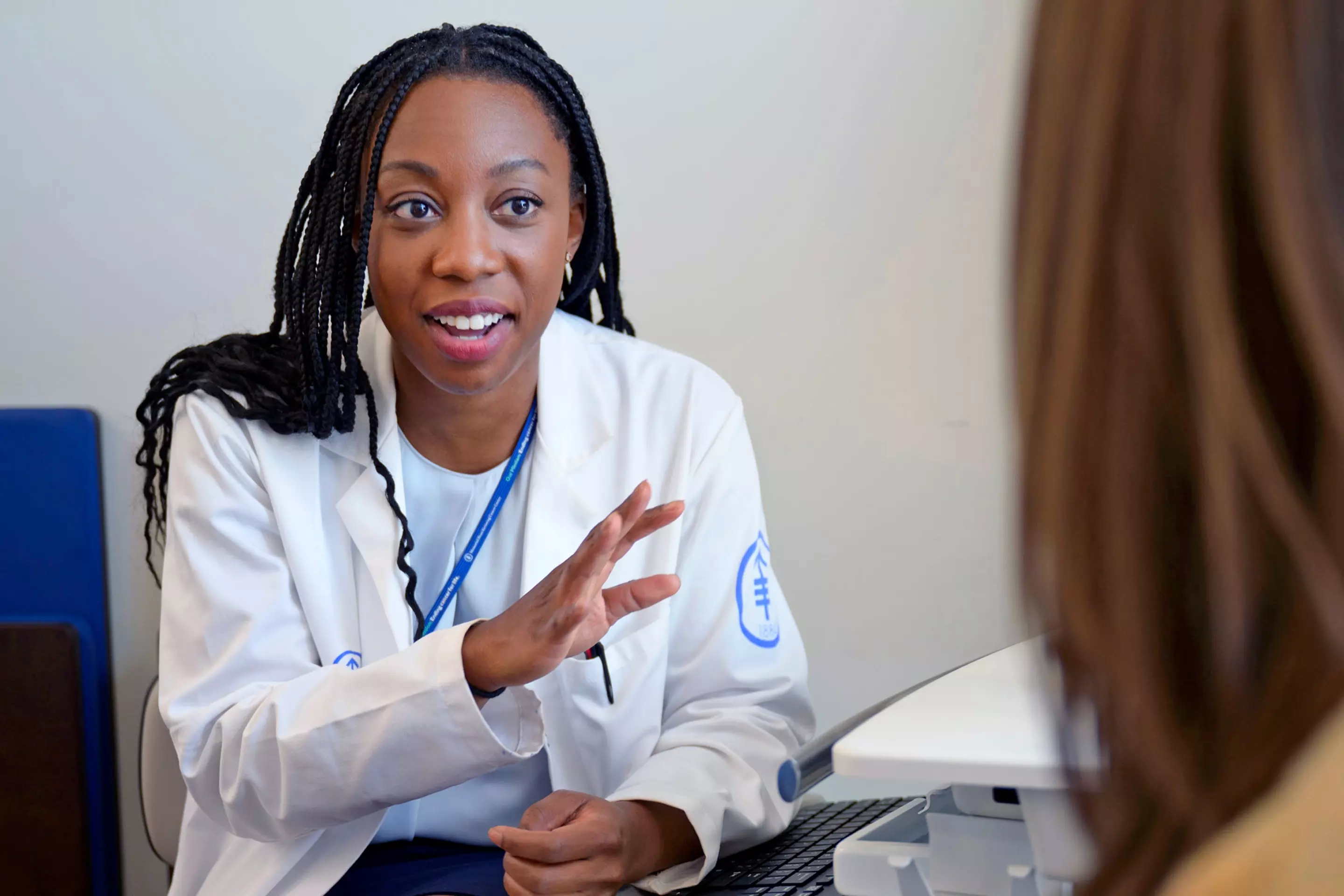 Thoracic surgeon Dr. Alexis Chidi is talking with a patient.