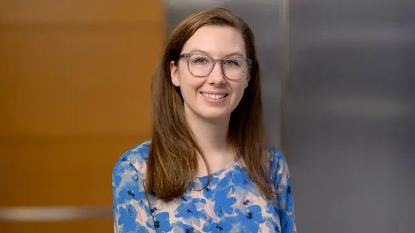 Allyson Gillespie, smiling and dressed in a business outfit, is at MSK in New York City. 